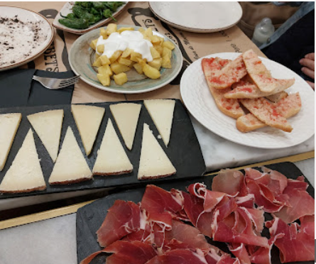 Tabla de quesos, jamón y pan con tomate